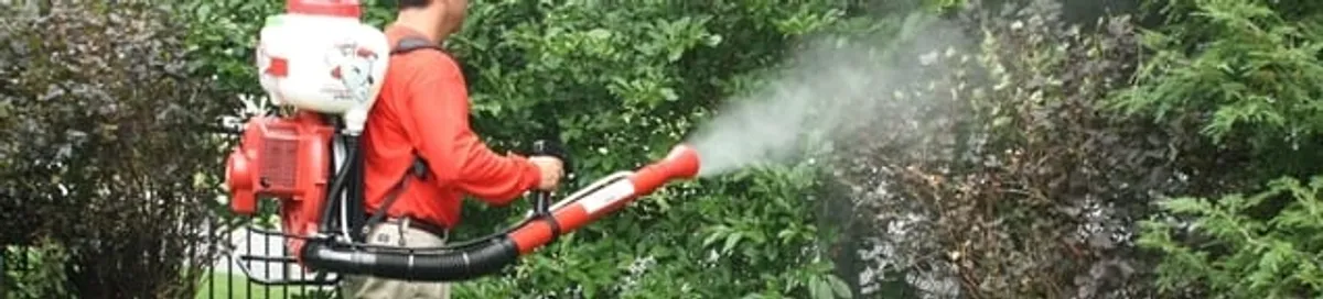 Mosquito control technician fogging shrubs and landscaping for mosquito treatment in Syracuse, NY